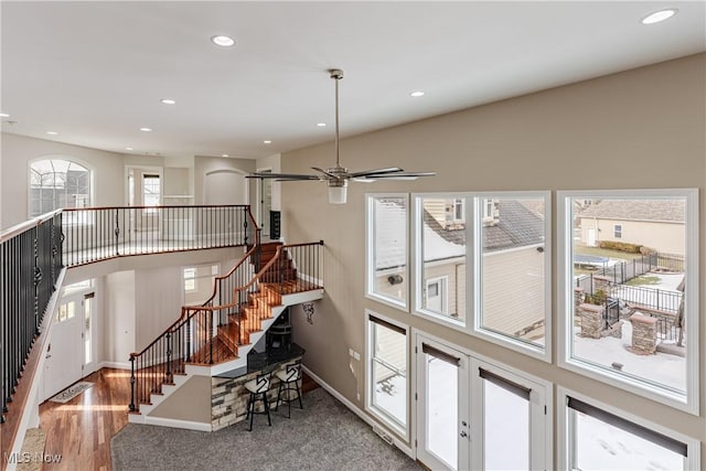 interior space featuring a ceiling fan, recessed lighting, baseboards, and wood finished floors