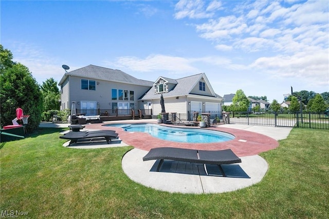 view of swimming pool featuring a fenced in pool, fence, a patio, and a lawn