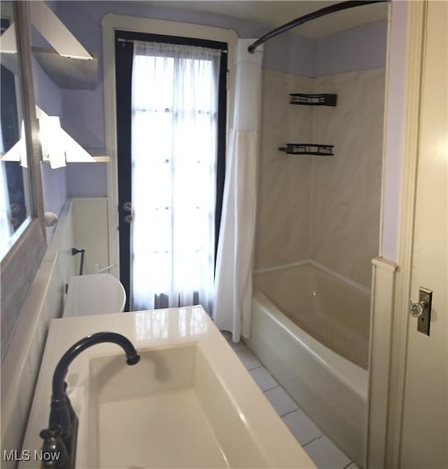 full bathroom with shower / bath combo with shower curtain and tile patterned floors