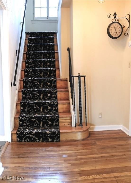 stairs featuring baseboards and wood finished floors