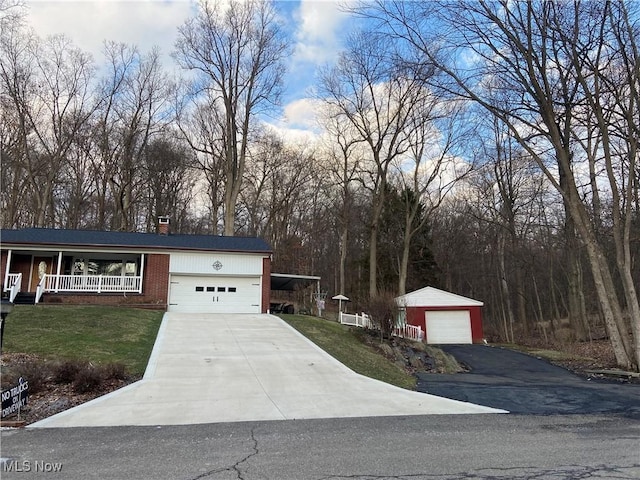 view of front of property featuring a garage, brick siding, a chimney, a porch, and a front yard