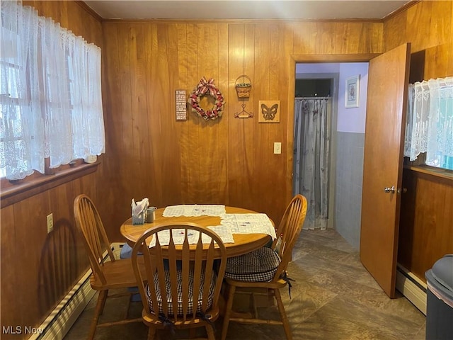 dining room with wood walls and a baseboard radiator