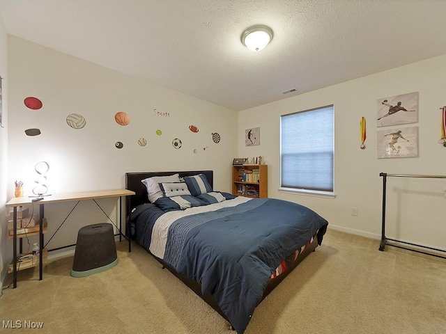 bedroom featuring light carpet, visible vents, and a textured ceiling