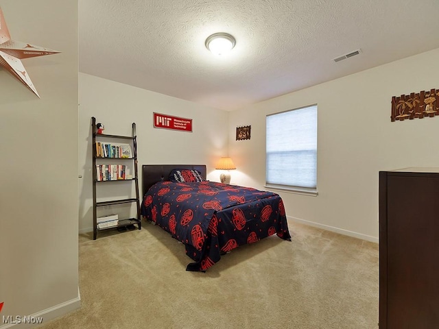 bedroom with a textured ceiling, carpet, visible vents, and baseboards