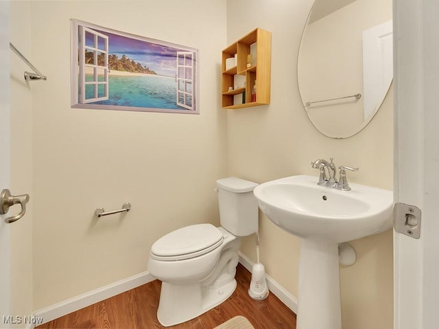 bathroom featuring baseboards, toilet, and wood finished floors