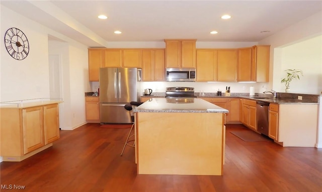 kitchen featuring appliances with stainless steel finishes, a sink, and light brown cabinetry