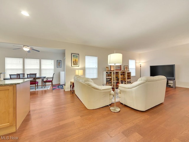 living area featuring light wood-style floors and ceiling fan