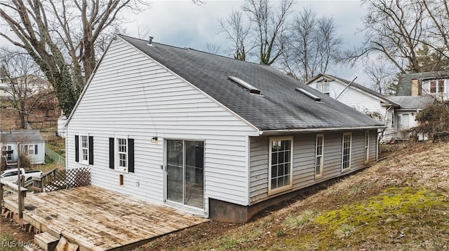 back of house with a shingled roof and a deck