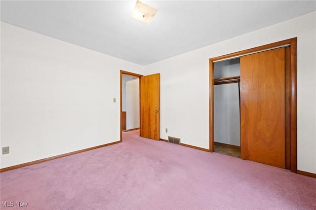 unfurnished bedroom with carpet floors, a closet, visible vents, and baseboards