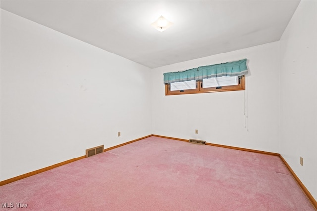 carpeted spare room featuring visible vents and baseboards