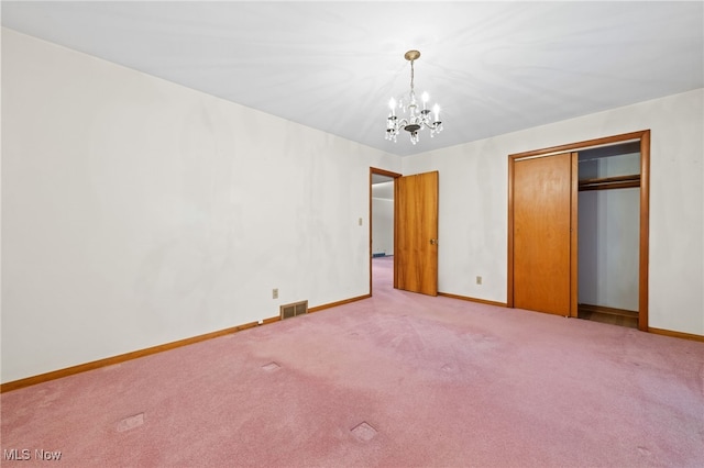 unfurnished bedroom featuring baseboards, visible vents, a chandelier, and carpet flooring