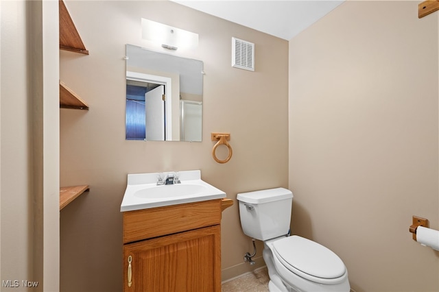 bathroom with toilet, vanity, visible vents, and baseboards