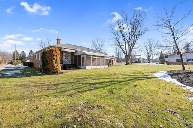 view of yard with entry steps and a sunroom