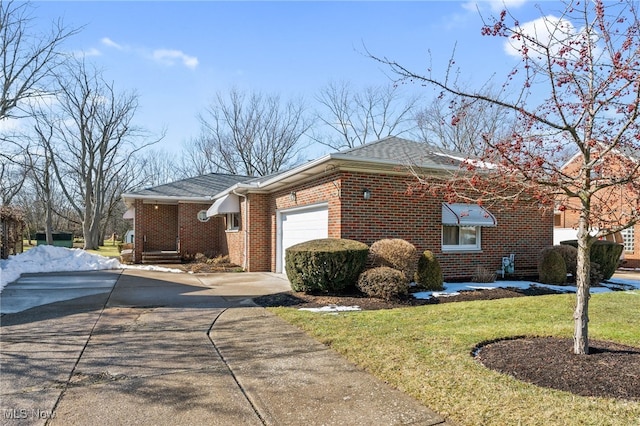 view of front of home featuring a garage, concrete driveway, brick siding, and a front yard