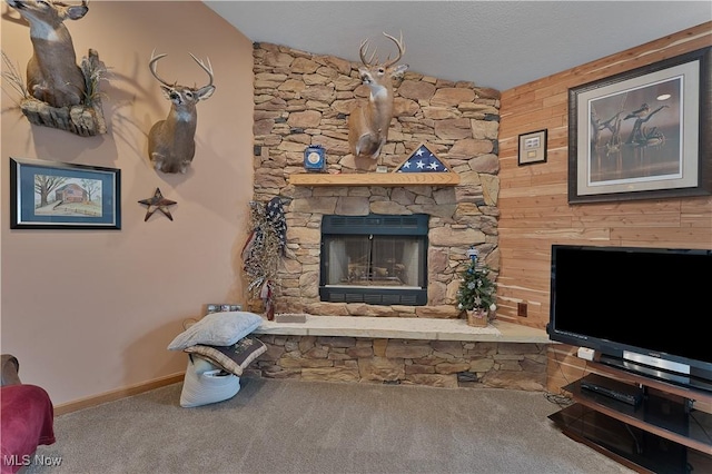 living area with carpet, a fireplace, baseboards, and a textured ceiling