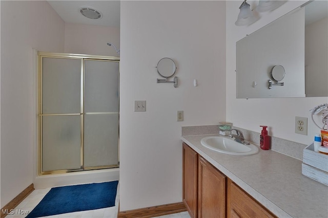 bathroom with a shower stall, visible vents, and vanity