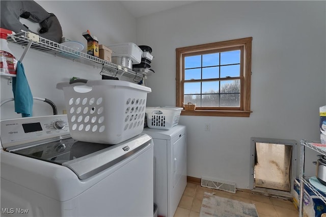 laundry area with light tile patterned floors, visible vents, separate washer and dryer, laundry area, and baseboards