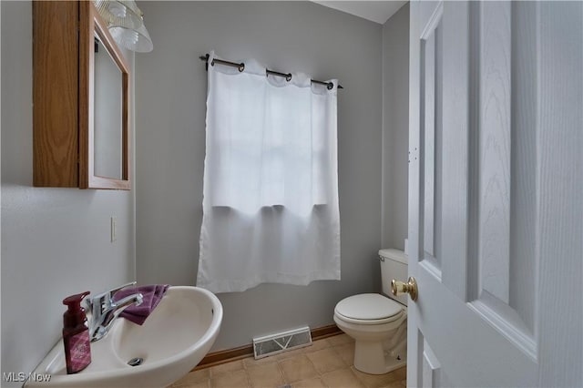 bathroom featuring visible vents, a sink, and toilet