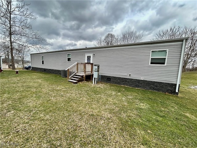 back of house with crawl space, central AC, and a yard