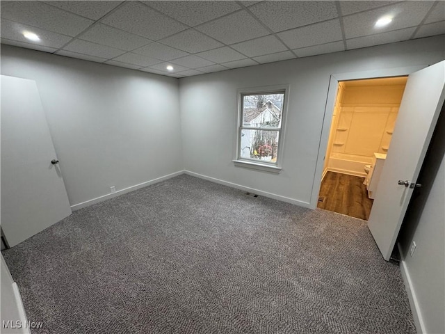 unfurnished bedroom featuring a paneled ceiling, carpet flooring, baseboards, and recessed lighting