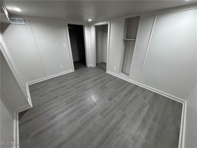 unfurnished bedroom featuring recessed lighting, wood finished floors, visible vents, and multiple closets