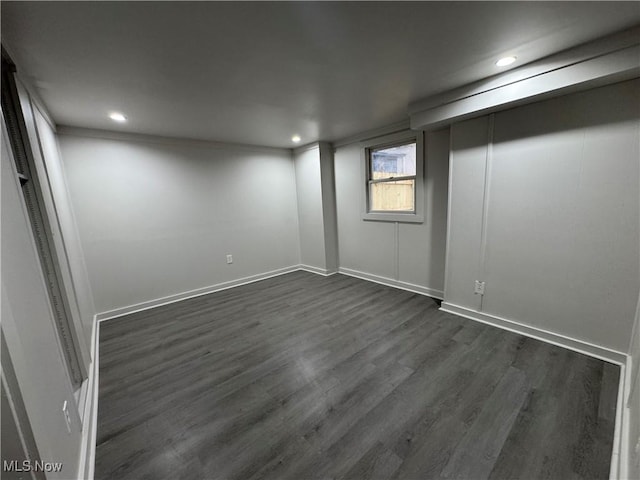 below grade area with baseboards, dark wood-type flooring, and recessed lighting