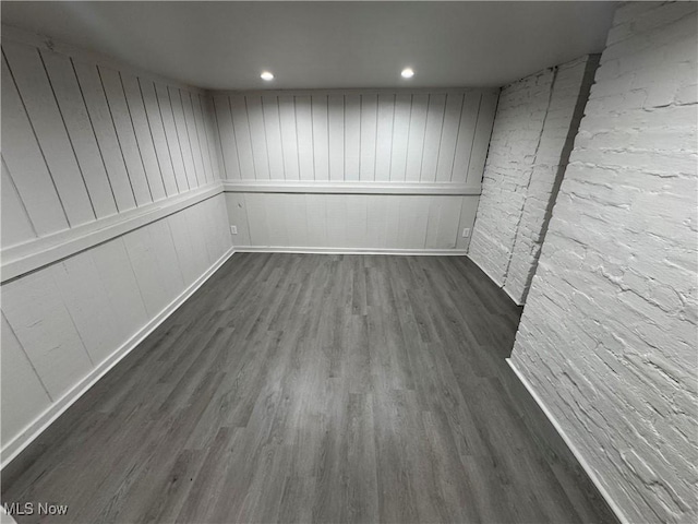 empty room with recessed lighting, dark wood-style flooring, and baseboards