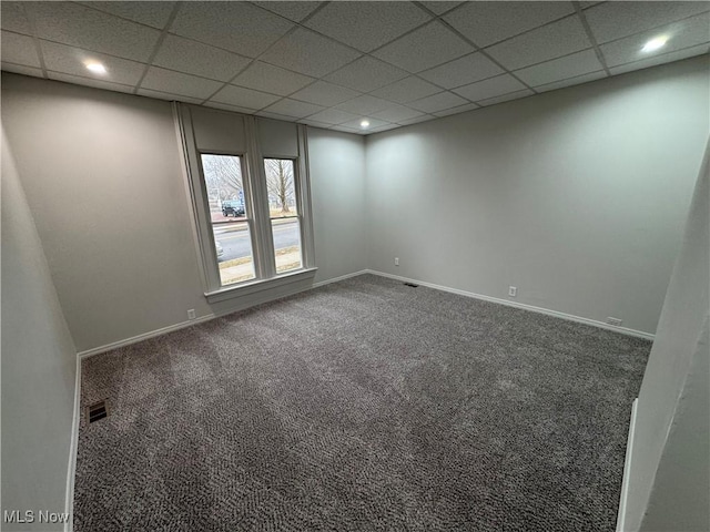 carpeted empty room with baseboards, visible vents, a drop ceiling, and recessed lighting