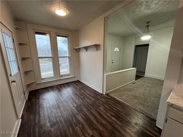 interior space with a textured ceiling, dark wood-style flooring, and baseboards