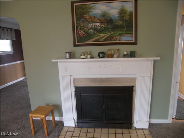 interior details with arched walkways, a fireplace with flush hearth, baseboards, and carpet floors