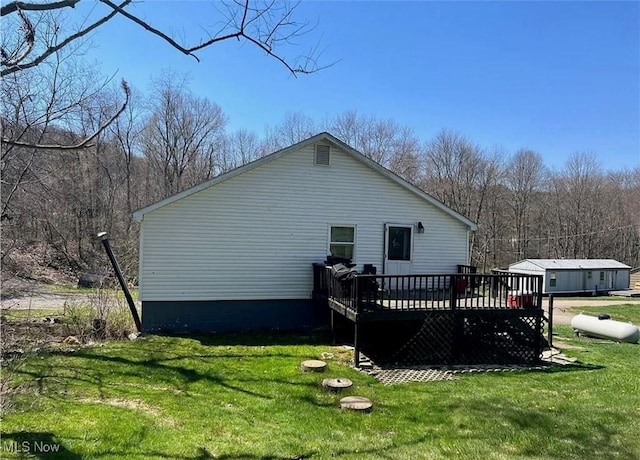 back of house with a deck and a yard