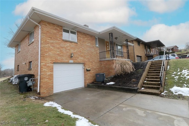 exterior space with concrete driveway, brick siding, an attached garage, and central AC unit