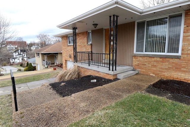 exterior space with covered porch and brick siding