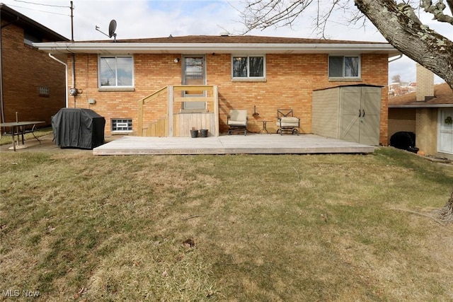 back of property with brick siding, a lawn, and a wooden deck