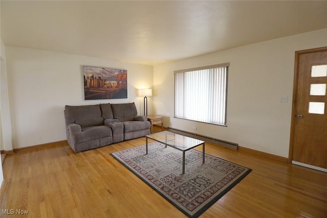 living room with a baseboard heating unit, baseboards, and wood finished floors