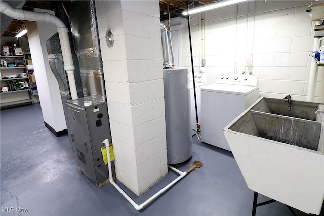 interior space featuring concrete block wall, laundry area, independent washer and dryer, water heater, and a sink