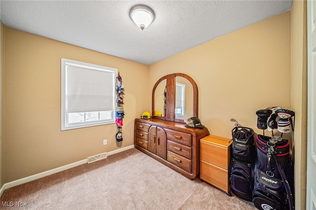 bedroom with light carpet, baseboards, visible vents, and a textured ceiling