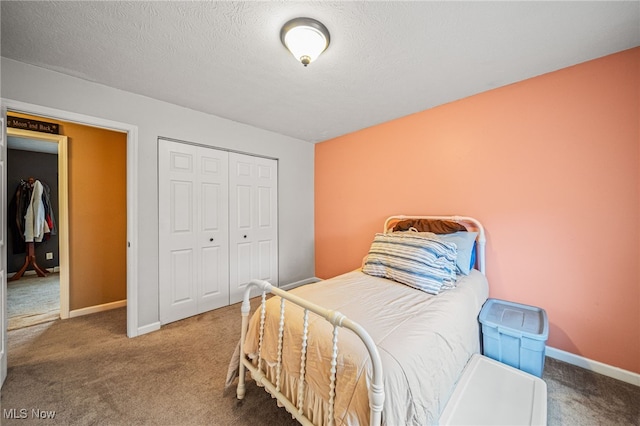 bedroom with a textured ceiling, a closet, carpet, and baseboards