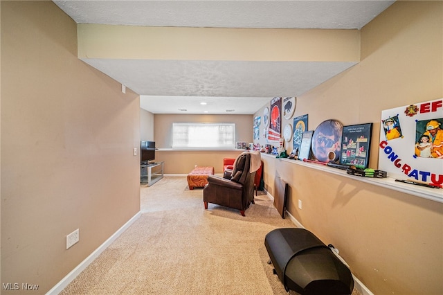 sitting room featuring carpet, a textured ceiling, and baseboards