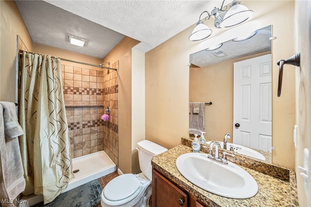 bathroom featuring visible vents, toilet, a tile shower, vanity, and a textured ceiling