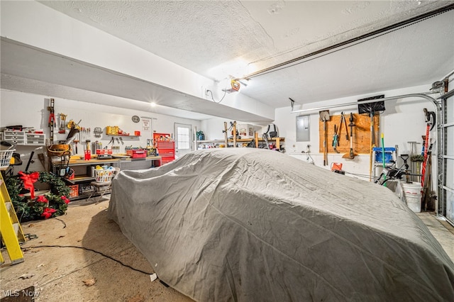 garage featuring a garage door opener, electric panel, and a workshop area