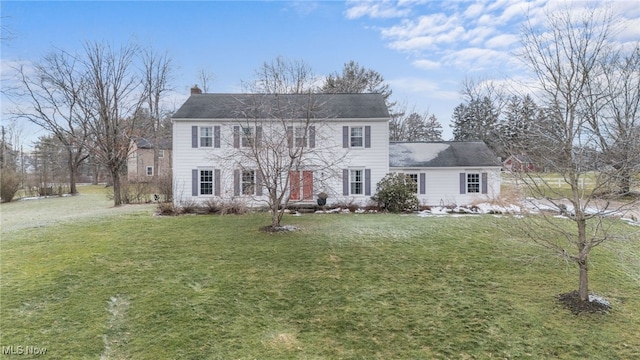 colonial inspired home with a chimney and a front lawn