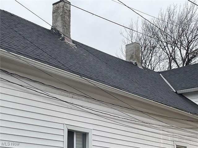 exterior details featuring roof with shingles and a chimney