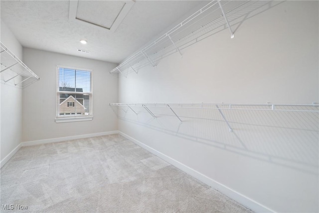 spacious closet with carpet floors and attic access