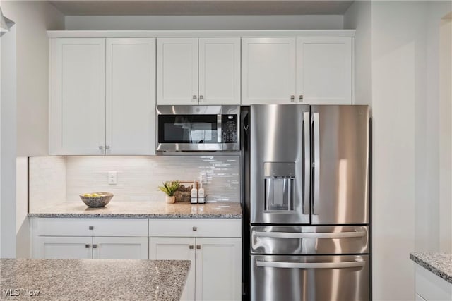 kitchen featuring tasteful backsplash, appliances with stainless steel finishes, and white cabinets