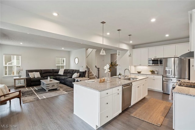 kitchen featuring light stone counters, dark wood-type flooring, a sink, white cabinetry, and appliances with stainless steel finishes