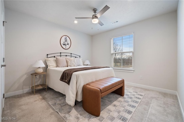 bedroom with a ceiling fan, light colored carpet, visible vents, and baseboards