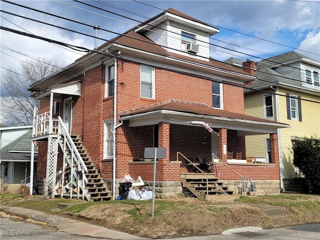 traditional style home featuring covered porch, brick siding, and cooling unit