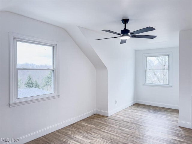 bonus room featuring lofted ceiling, a ceiling fan, baseboards, and wood finished floors