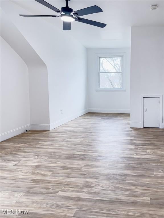 bonus room with ceiling fan, vaulted ceiling, wood finished floors, and baseboards